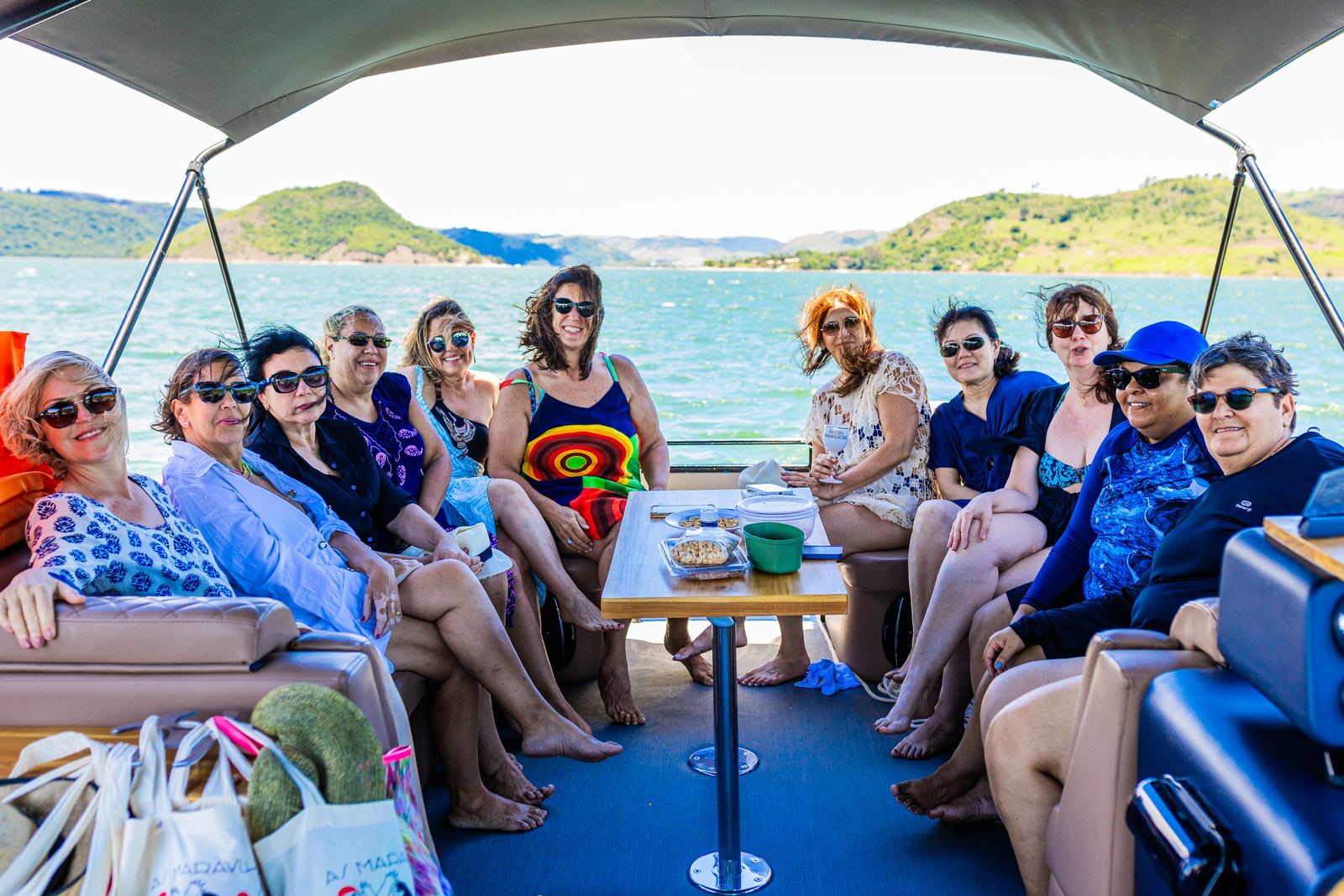 Grupo sentado no deck do barco com a represa ao fundo