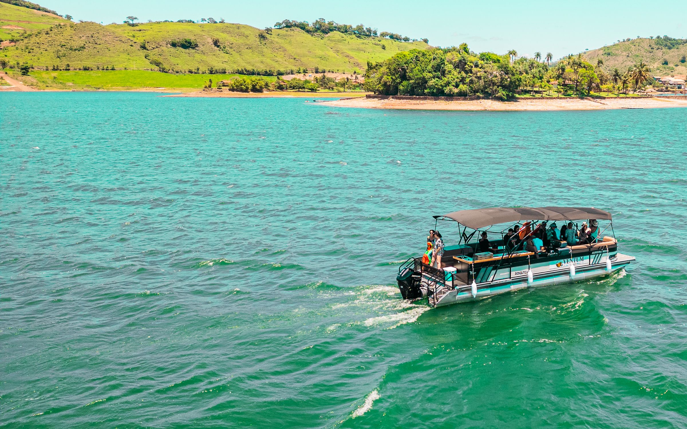 Barco da Ventum navegando com convidados nas águas turquesa da Represa de Chavantes
